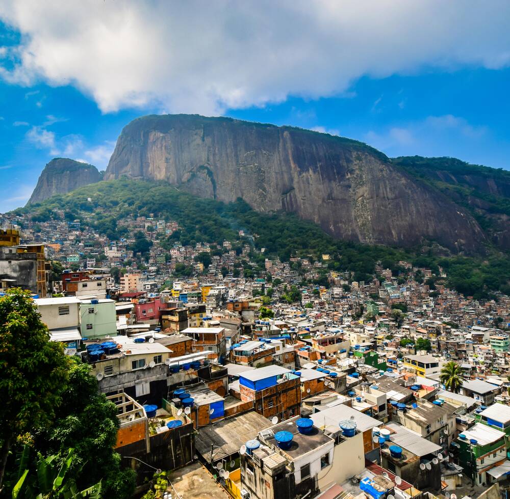 A large cliff overlooking a mass of colourful houses.